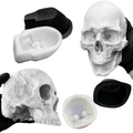 Skull-shaped ice cube trays with black and white silicone molds on a white background