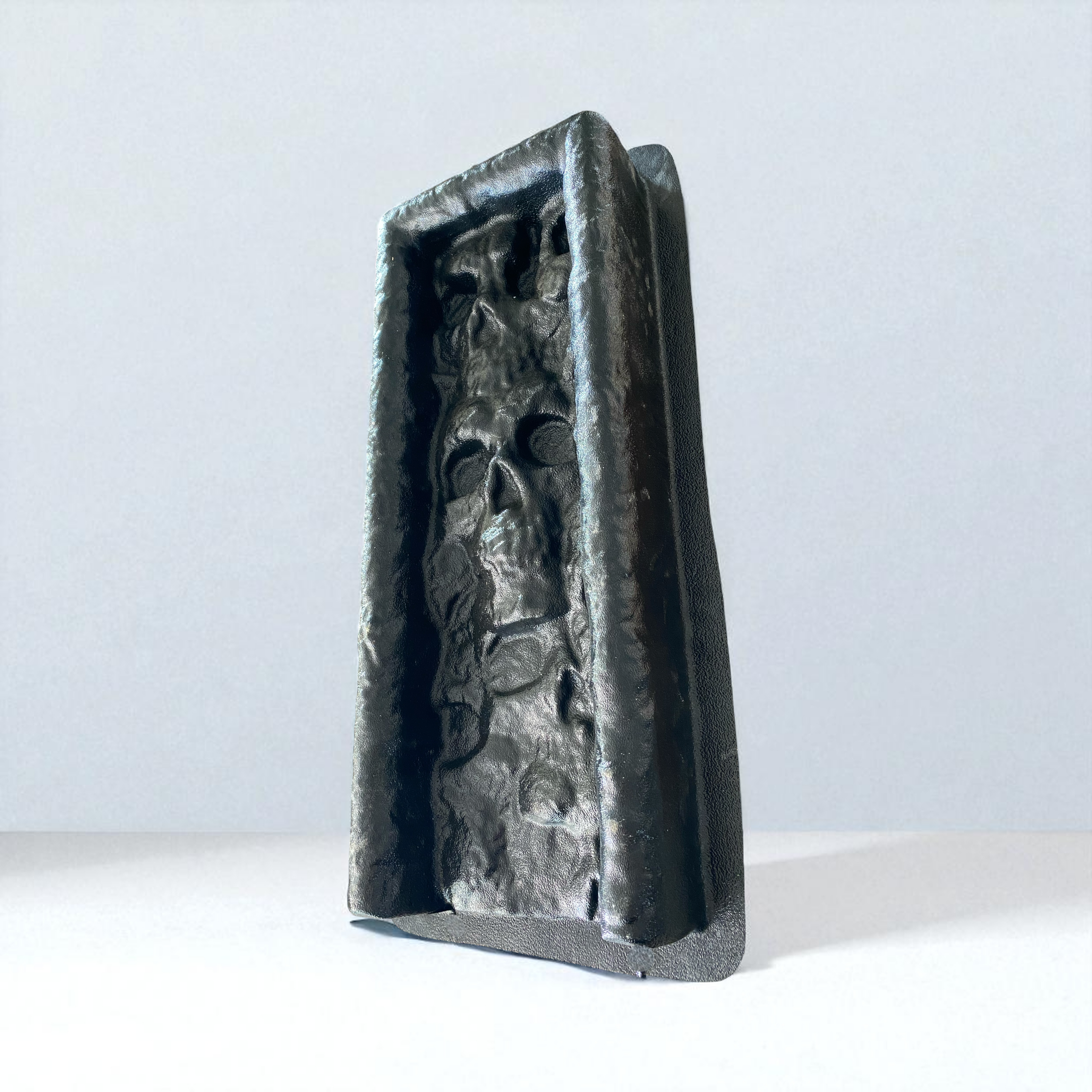 Decorative stone sculpture with intricate carvings on a white background