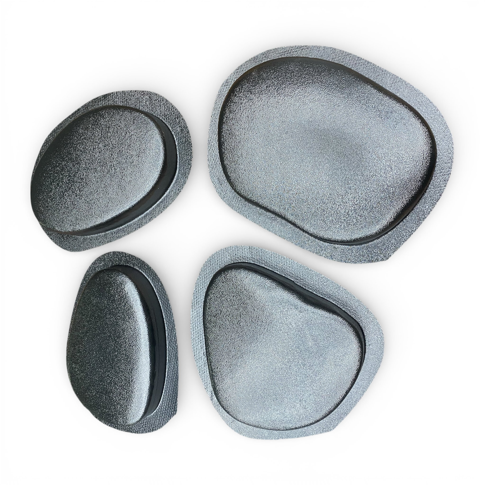 Set of four gray stone-like coasters on a white background