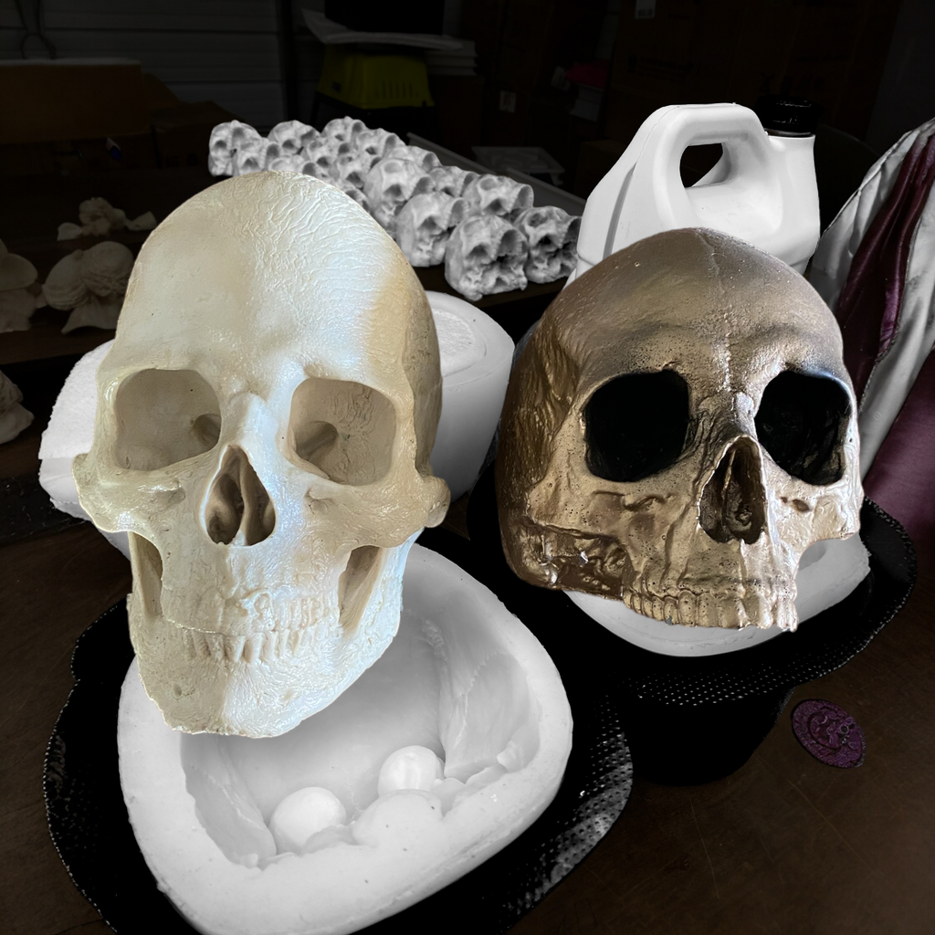 Two skull-shaped molds on a dark surface with a blurred background.