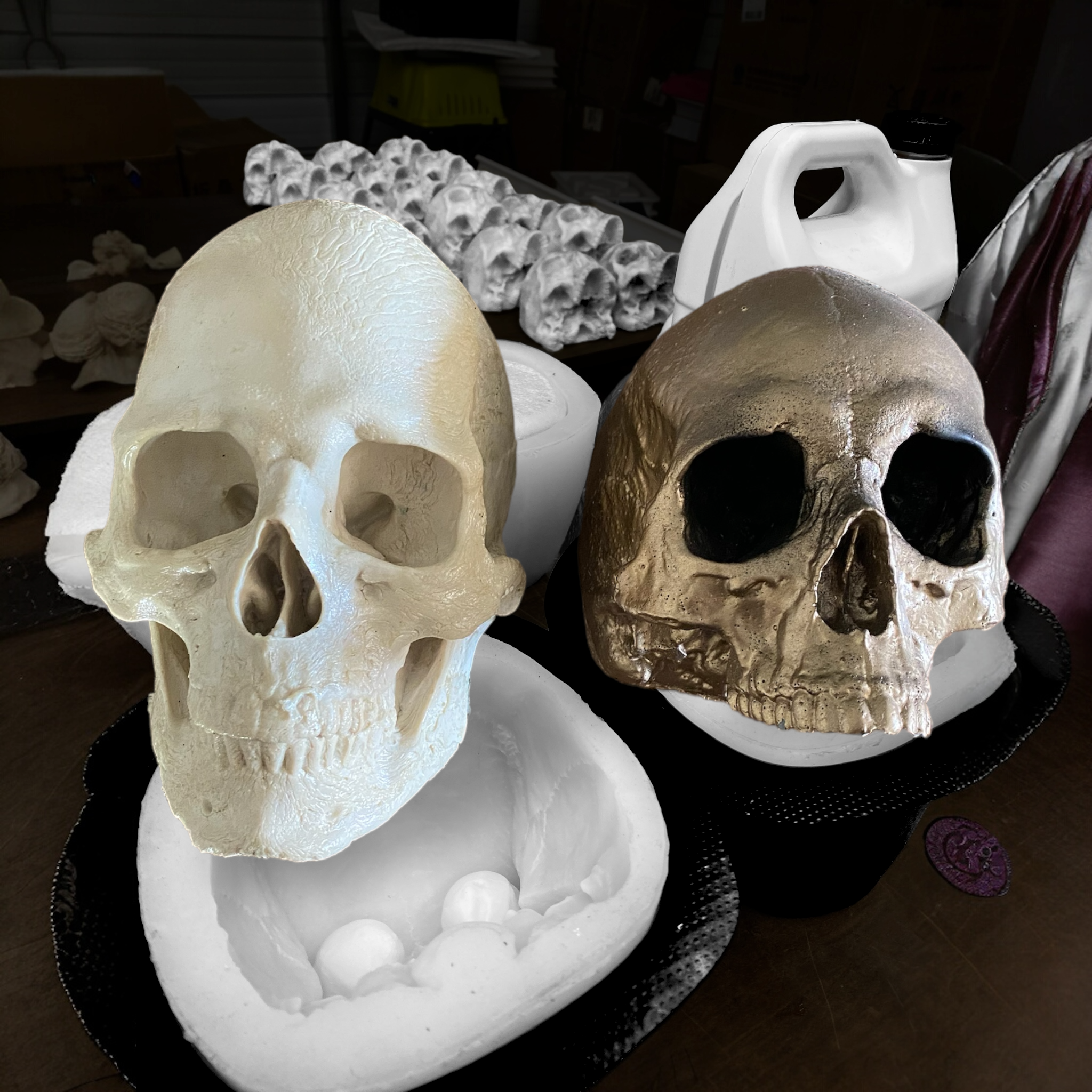 Two skull-shaped molds on a dark surface with a blurred background.