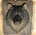 14-inch bear head ABS casting mold by Pacific Mold Design showing realistic bear face with 4-inch snout depth mounted on wood grain plank texture for concrete and plaster cabin and garden wall art
