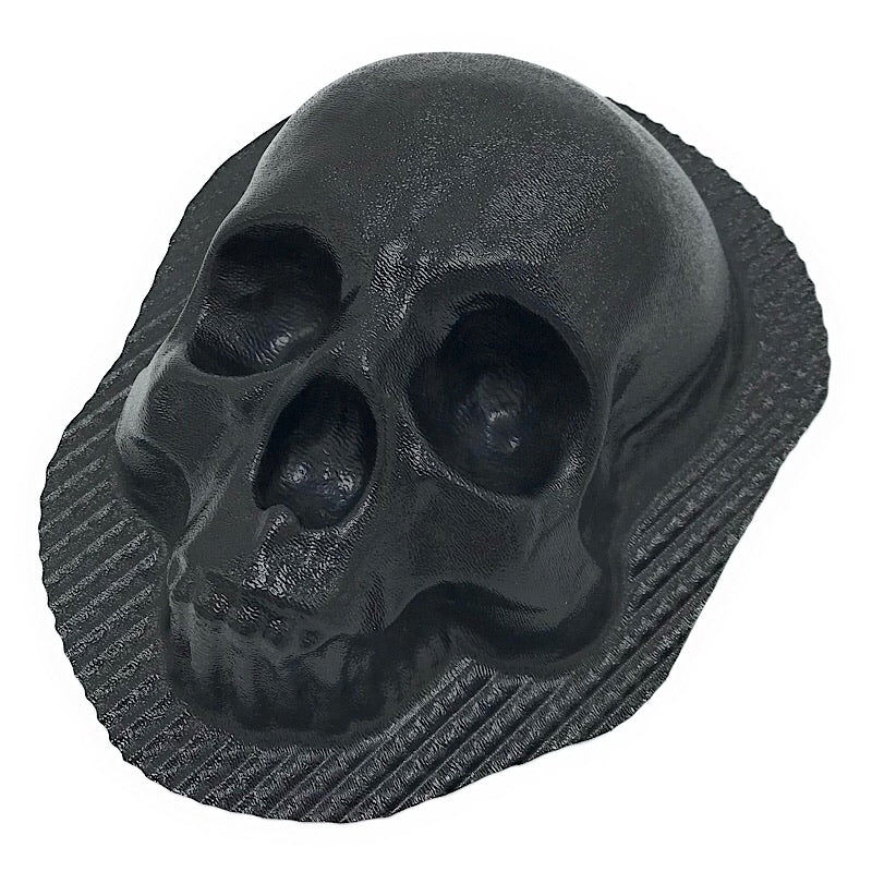 Set of white plaster skull castings arranged decoratively around a fireplace with black metal screen, showing finished results from Pacific Mold Design skull fireplace mold set