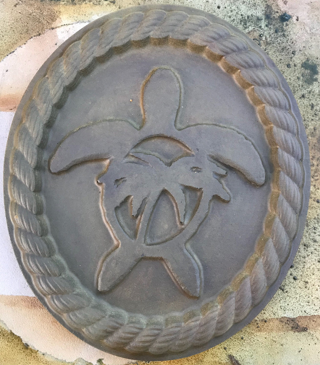 A mold with a sea turtle design used for casting materials like concrete or plaster.
