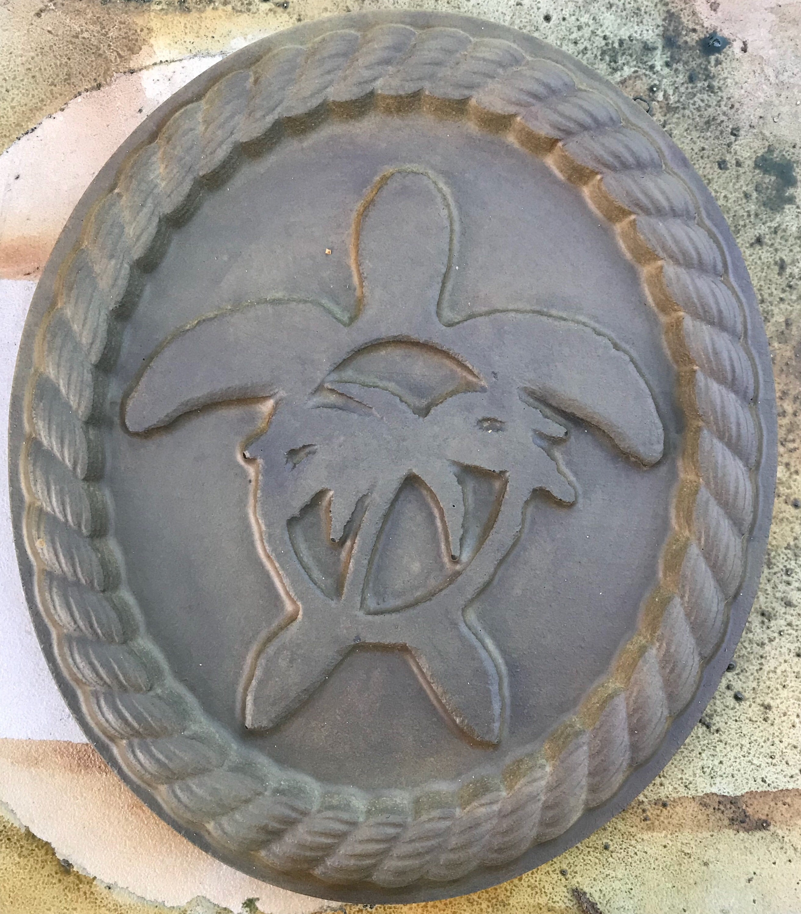 A mold with a sea turtle design used for casting materials like concrete or plaster.
