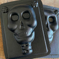 A black ABS mold relief of a skull, likely used for casting concrete or plaster for Day of the Dead decorations.