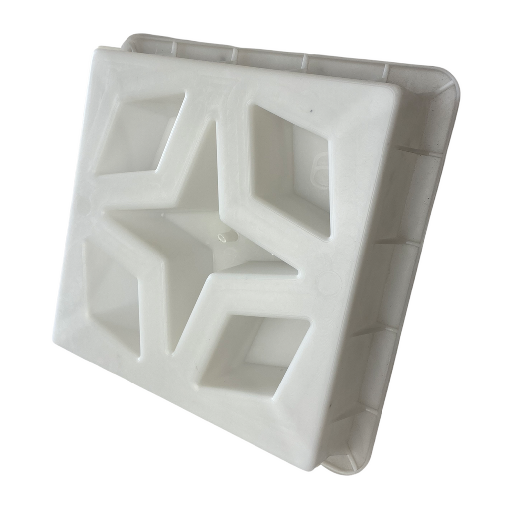 A white concrete breeze block with a geometric pattern.