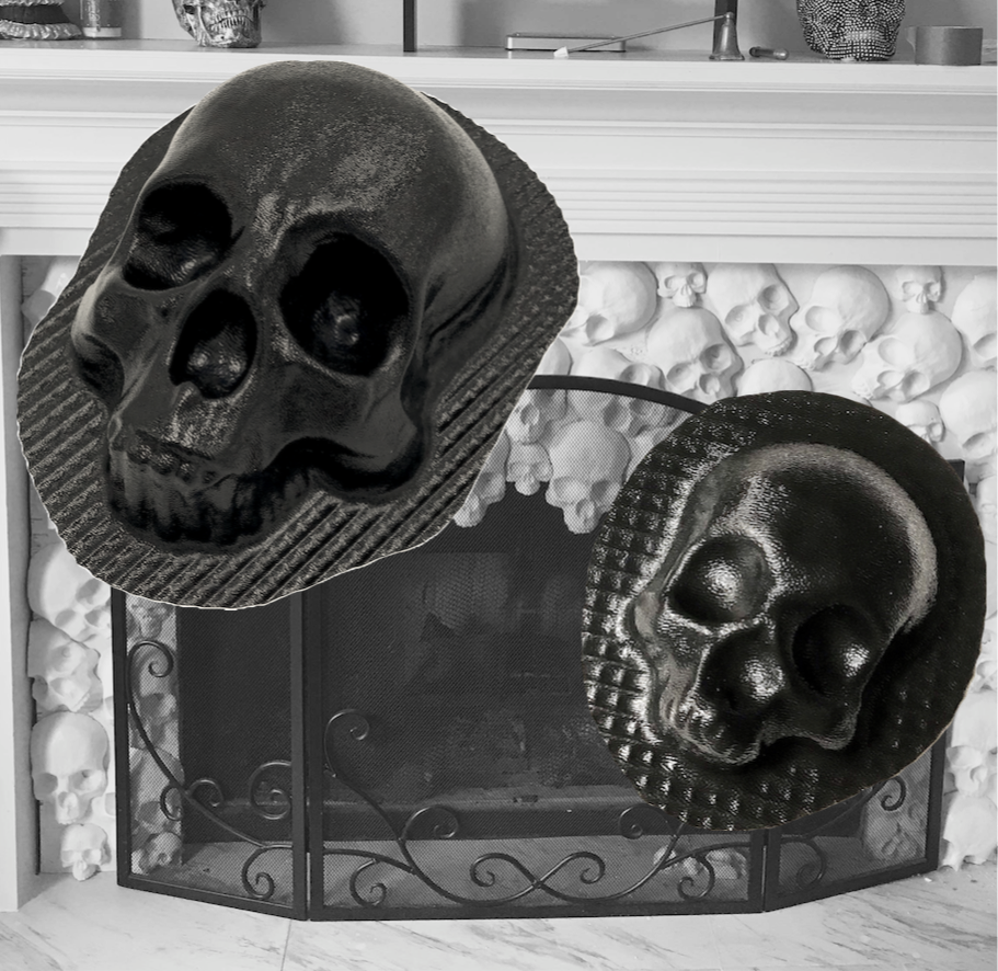 Set of white plaster skull castings arranged decoratively around a fireplace with black metal screen, showing finished results from Pacific Mold Design skull fireplace mold set